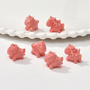 Close-up of pink resin unicorn charms for DIY jewelry making with wings and glossy finish