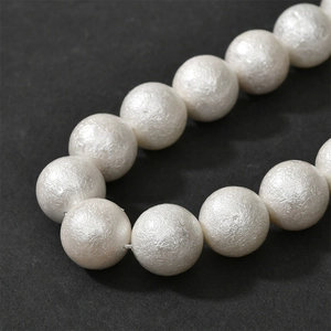 Macro shot of white cotton pearl beads with unique textured finish for DIY jewelry