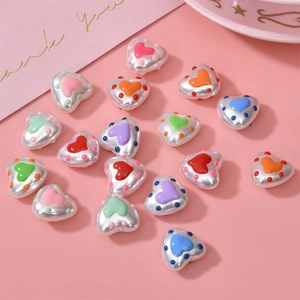 Detailed view of heart-shaped pearl resin beads with colorful dot accents for DIY jewelry