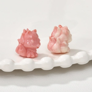 Macro detail of hand-carved pink sea bamboo fox beads for DIY jewelry making