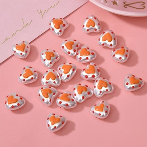DIY heart shaped white pearl beads with orange hearts and red dots on pink background