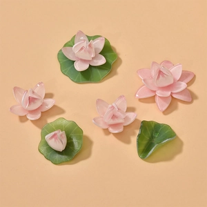 Macro detail of acrylic lotus flowers and green leaves for DIY hair jewelry making