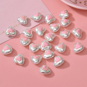 Macro shot of pearl heart-shaped resin beads with pink hearts and green polka dots