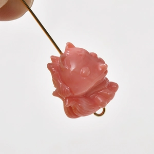 Detailed view of pink translucent fox-shaped bead with golden DIY jewelry attachment