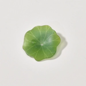 Macro detail of translucent green acrylic lotus leaf bead with intricate vein textures