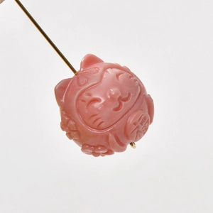 Detailed view of pink hand-carved cat charm with floral reliefs for DIY jewelry