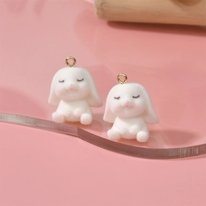 Gros plan de pendentifs lapin floqués blancs avec détails roses et anneaux dorés