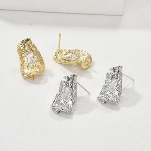 Dettaglio di componenti per orecchini texture lava oro e argento con zircone rettangolare