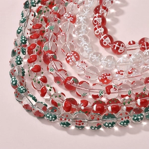 Close-up of festive Christmas-themed glass beads with Santa hats and snowflakes