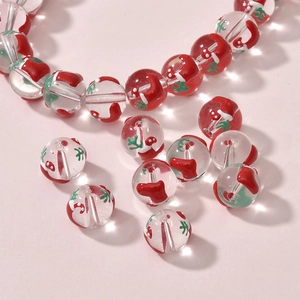 Close-up of glass Christmas beads with red stocking and white snowflake patterns for DIY jewelry