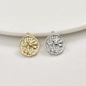 Macro shot of 14k gold and silver hollow flower pendants for DIY jewelry making