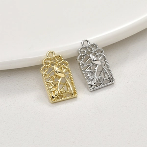 Macro detail of bird and floral relief on openwork gold and silver pendant charms