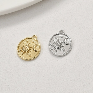 Close-up of gold and silver 14k plated sun and moon coin pendants for jewelry making