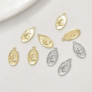 Detailed view of 14k gold and silver star moon pendants with brushed texture finish