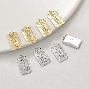 Macro view of 14k gold plated tarot-style pendants with hand, star, and moon details