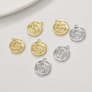 Detailed relief of 14k gold and silver dragon coin charms for DIY jewelry making
