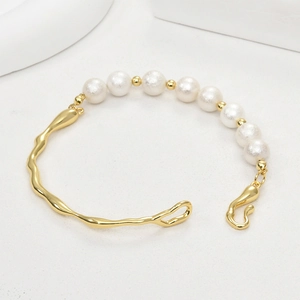 Close-up of 14k gold-plated irregular branch bracelet with white matte pearls and S-hook