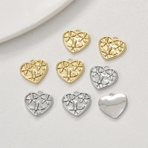 Detail of 14k gold-plated heart charms with embossed flower and dragonfly designs