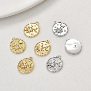 Detail of 14k gold celestial pendants with sun moon patterns and sparkling zircons