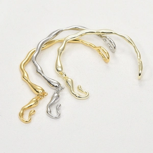 Detail of wavy irregular tree branch bracelets in gold and silver plating
