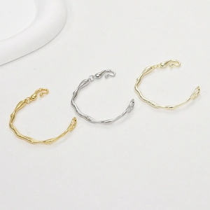 Detailed view of 14k gold and silver plated irregular wavy textured open bangles