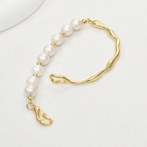 Detail of 14k gold plated irregular twig bracelet featuring organic fluid metal and pearls