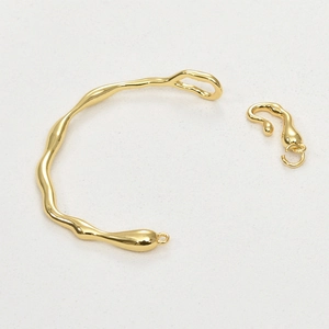 Detailed view of irregular 14k gold plated branch bangle with molten metal texture