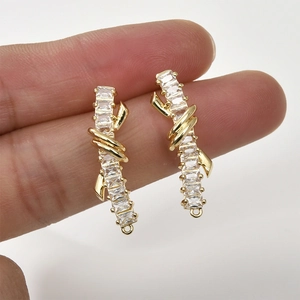 Detail of 14k gold plated ribbon bar earrings with zircon stones and link loops