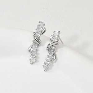 Close-up of silver ribbon knot earring parts with baguette-cut zircons for DIY jewelry