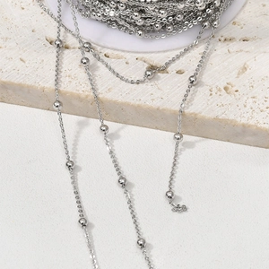 Close-up of silver-plated copper bead chain on a spool for DIY jewelry making