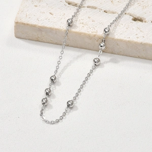 Elegant silver bead chain necklace for DIY jewelry on a marble background