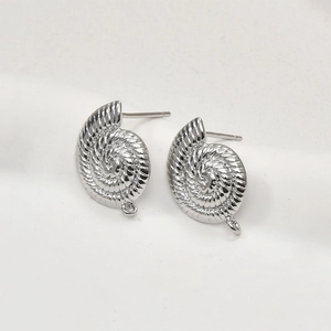 Vue macro de clous d'oreilles argentés en forme de coquillage pour la création de bijoux