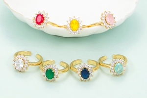 Makroaufnahme bunter ovaler Zirkonia-Ringe mit Mikro-Diamanten auf goldenen Bändern