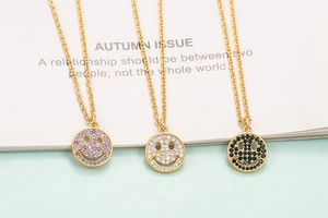 Detailed view of three smile face pendants with purple, white and black zircon stones