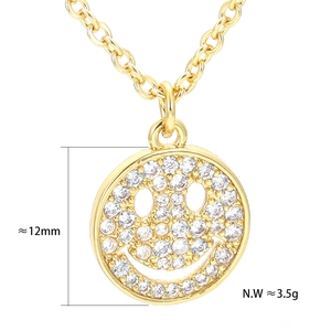 Macro detail of a 12mm smiley face pendant with zircons on a gold box chain necklace