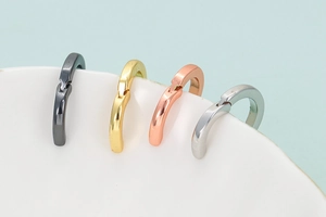 Poliierte kleine Creolen in Gunmetal, Gold, Roségold und Silber auf einer weißen Platte