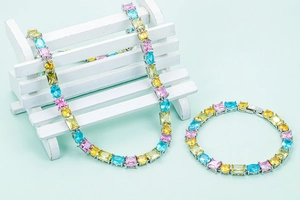 Nahaufnahme von Halskette und Armband mit bunten Zirkonia auf einer Deko-Mini-Bank