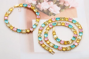 Nahaufnahme eines bunten Zirkonia-Schmucksets mit vergoldeter Halskette und Armband
