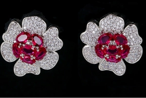 Detailed macro view of vintage floral earrings with red gemstones and zircon petals