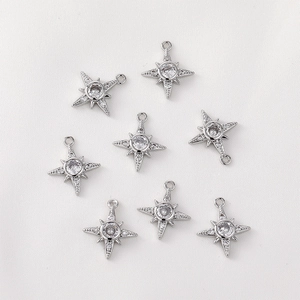 Macro detail of eight-pointed star charms with 14K gold plating and cubic zirconia