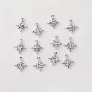 Macro shot of twelve silver eight-pointed star charms with micro-paved cubic zirconia