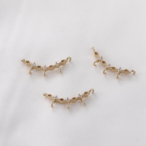 Dettaglio di ciondoli curvi placcati in oro con zirconi per la creazione di gioielli DIY