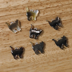 Macro shot of 7 shell pendants in cat shapes with iridescent luster for DIY jewelry
