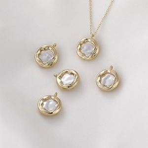 Vue macro de pendentifs ronds en perle baroque plaqués or 14k avec bords plissés d'art