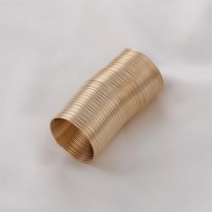Macro shot of gold spiral memory wire cylinder for DIY beaded ring jewelry making