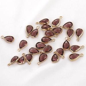 Macro view of teardrop purple crystal pendants with gold edges for jewelry making