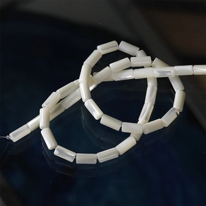 Macro shot of 5x10mm cylindrical white shell beads with natural iridescent pearl luster