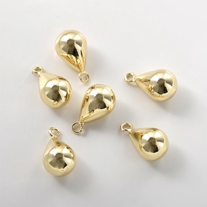 Close-up of six polished 14k gold-filled teardrop charms for DIY jewelry making
