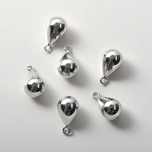 Macro shot of silver teardrop pendants with polished mirror finish and top jump rings