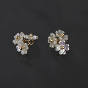 Exquisite pearl luster flower cluster stud earrings with gold plating on black background